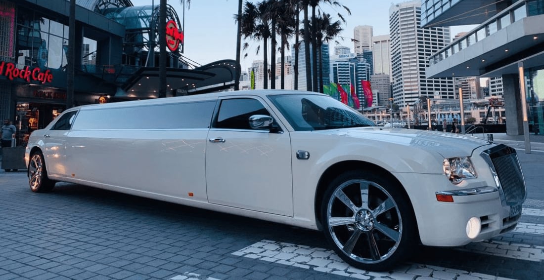 White Chrysler Super Stretch — exterior, city backdrop