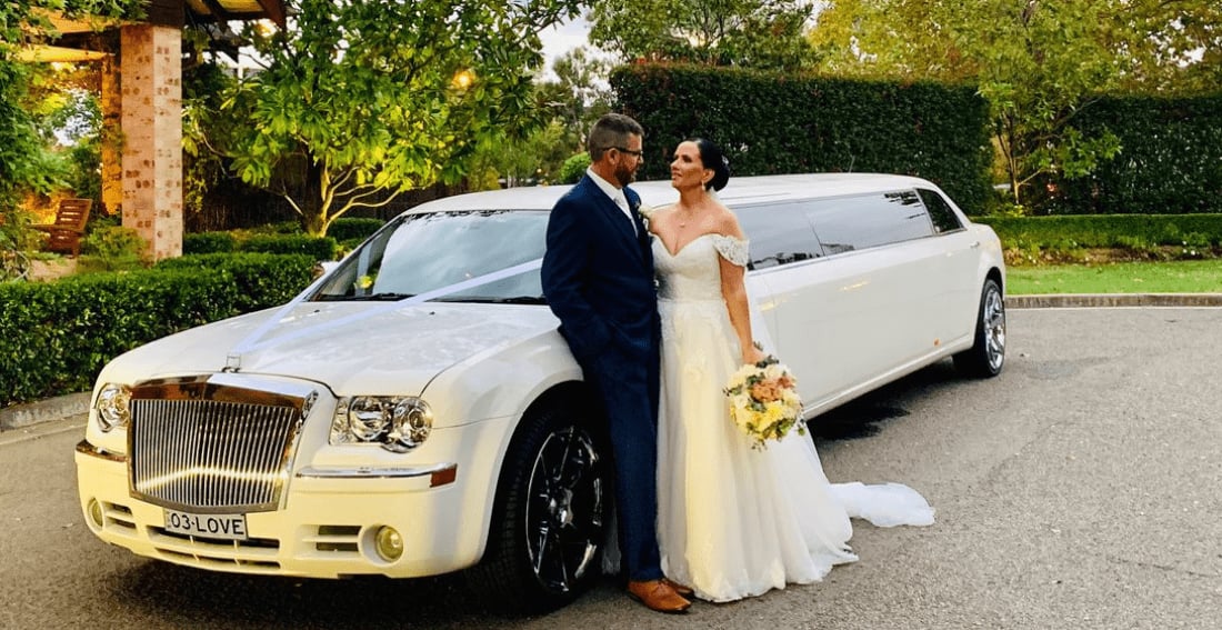 White Chrysler Super Stretch — exterior, with a wedding couple
