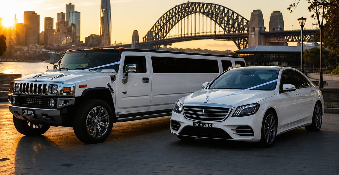 White Mercedes S Class AMG sedan beside a white Hummer stretch limousine at Sydney Harbour at sunset